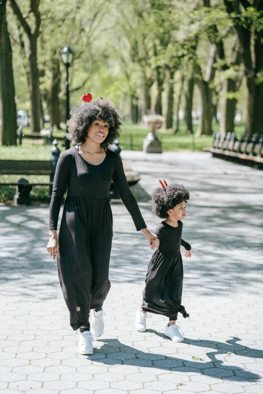 the woman is walking with her daughter through the park