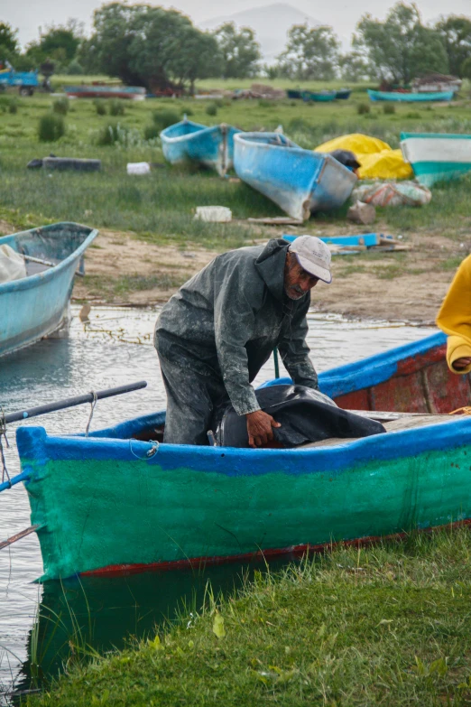 the man is trying to remove soing from the boat