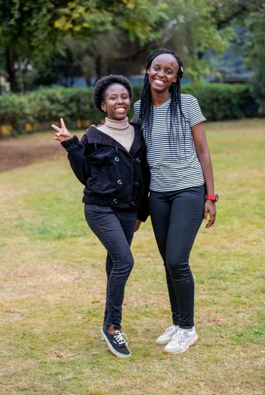 two girls smiling for the camera, one has a peace sign