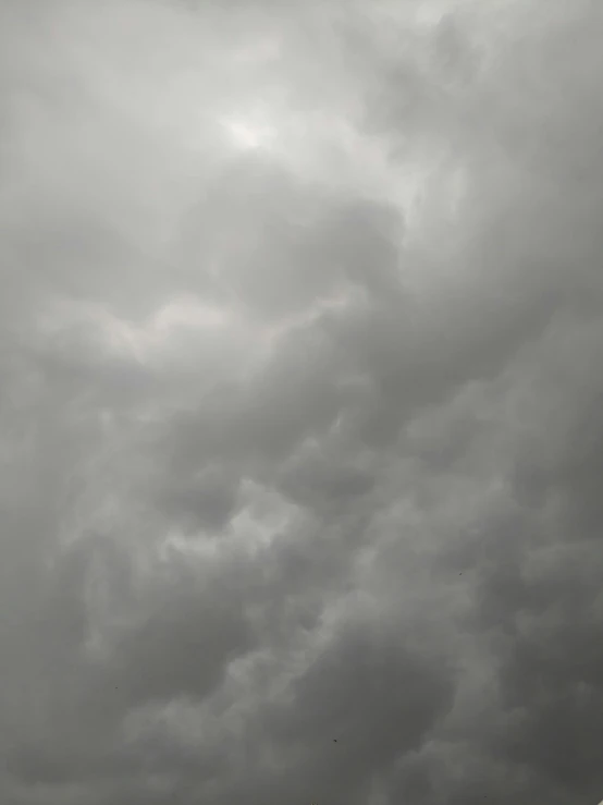 three people flying kites in a cloudy sky