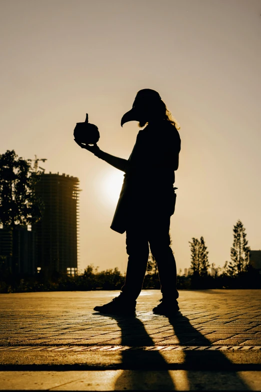 a person wearing a hat and holding a bird in their hand