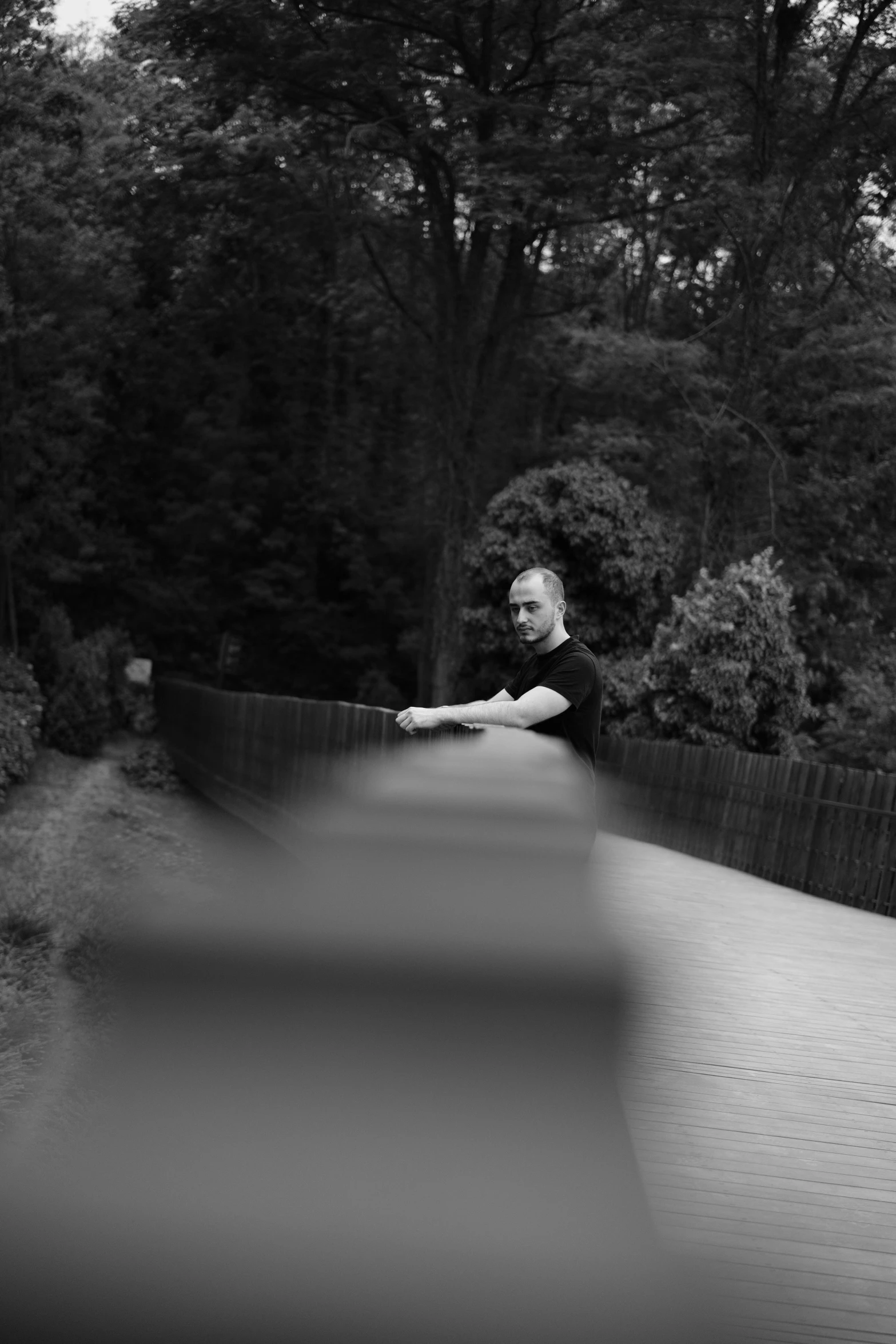 a black and white image of a man holding a tennis racquet on the street