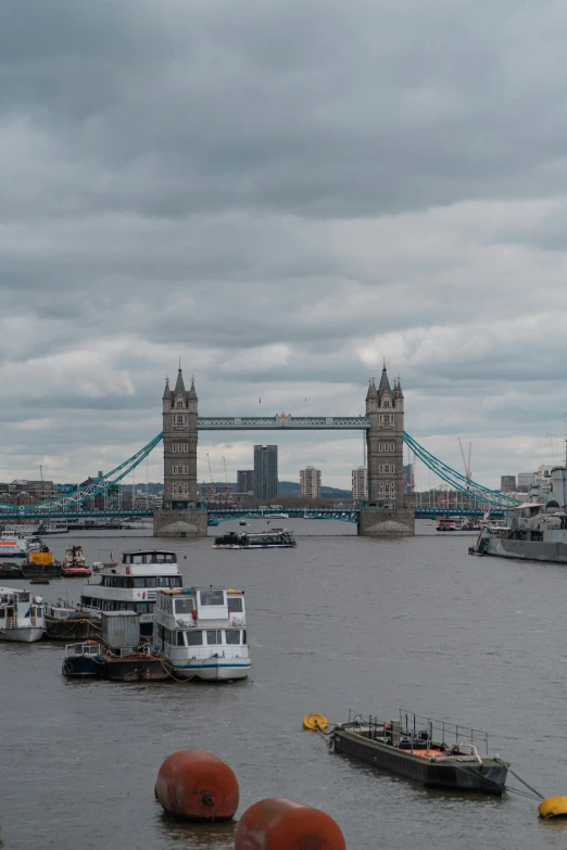 there is boats floating in the water by the bridge