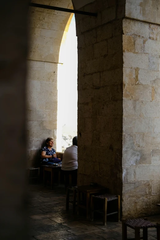 two people sitting inside of a building looking at each other