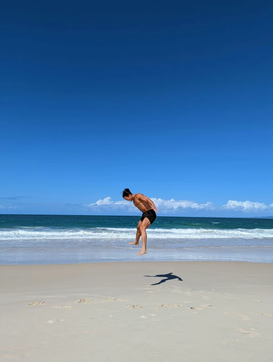 a man standing on top of a beach near the ocean