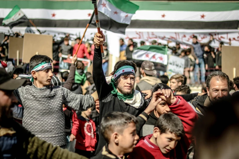 a crowd in a city with flags on the streets