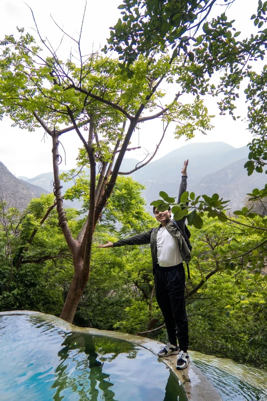 a man on top of a hill holding soing up