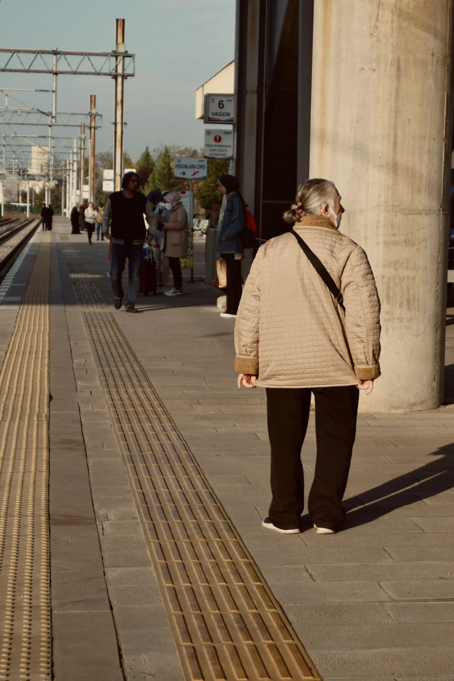 a person on a sidewalk near a train