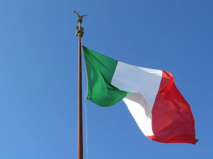 a large flag with a cross on the top flying in the wind