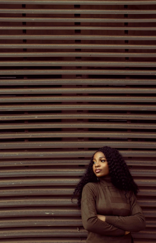 a beautiful woman posing against a corrugated wall