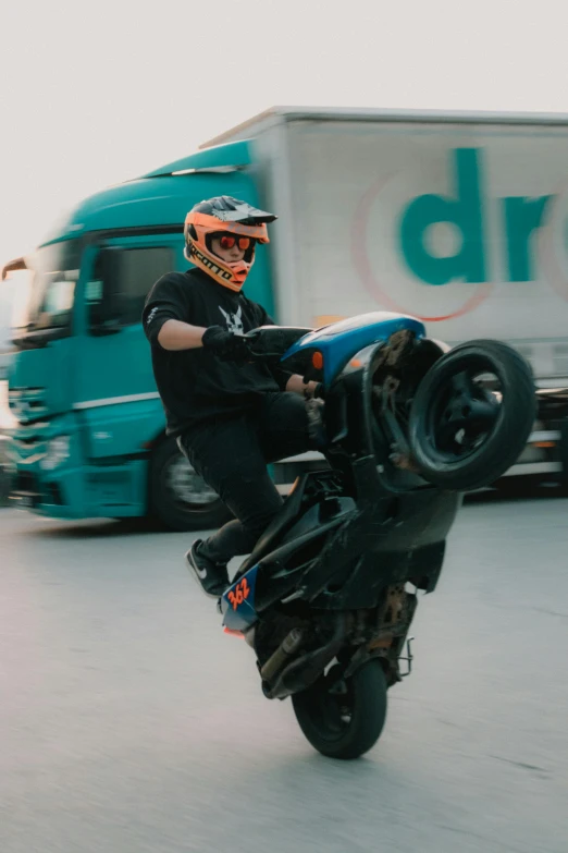 a man riding a motorcycle with a tire being thrown