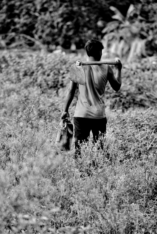 a person is walking through tall grass with a bag