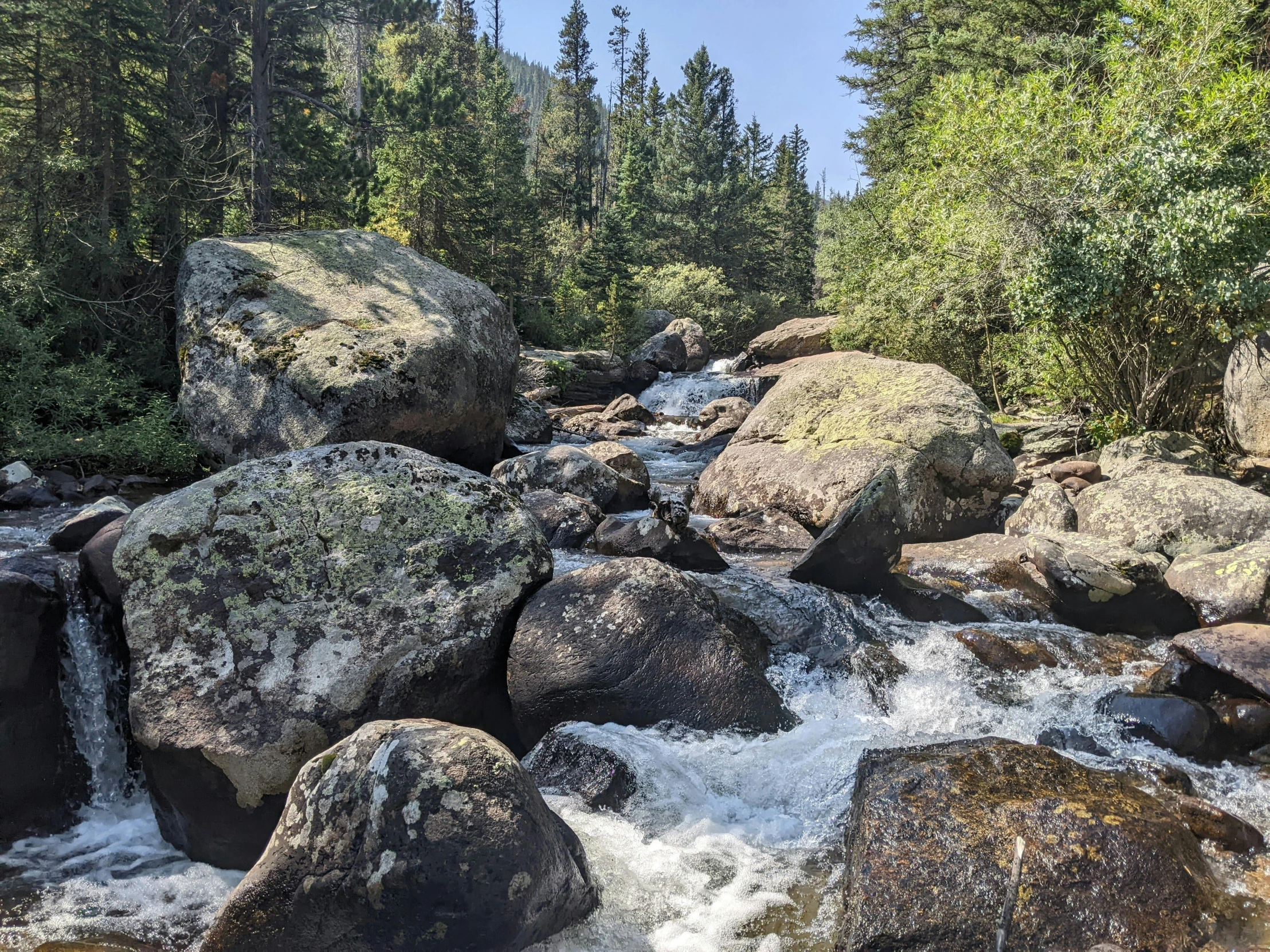 many large rocks sit by some water