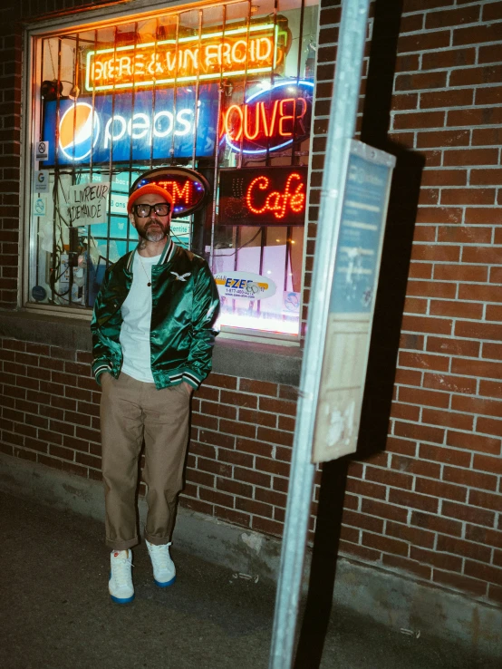 a man in green jacket standing in front of restaurant