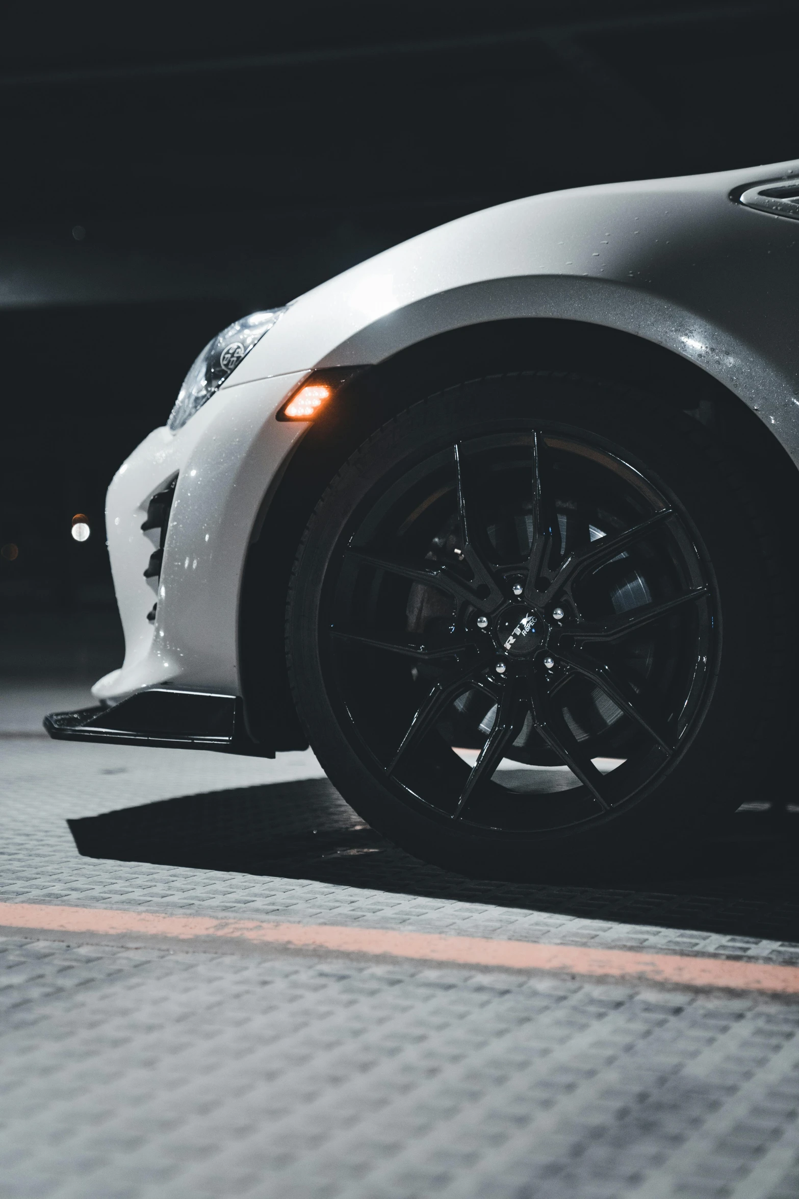 a gray and white sports car parked in a parking lot