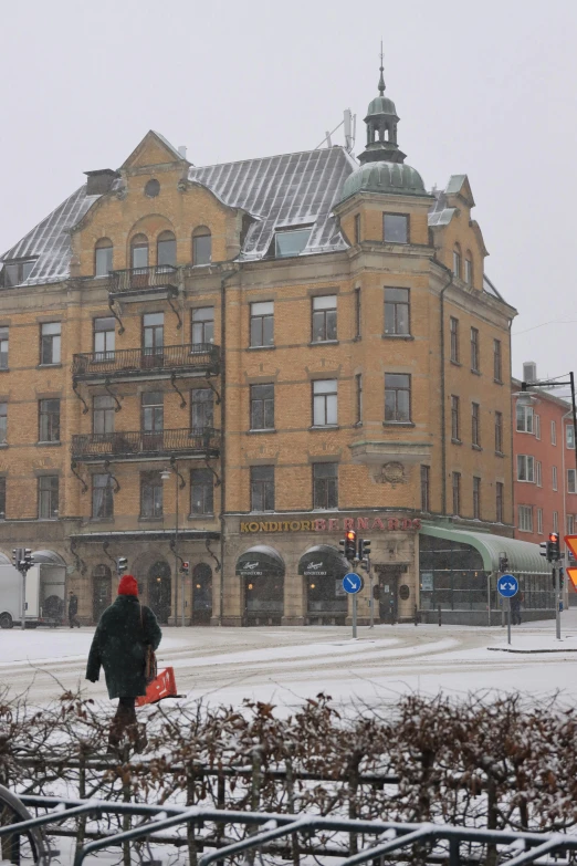 there is a man walking in front of a very large building