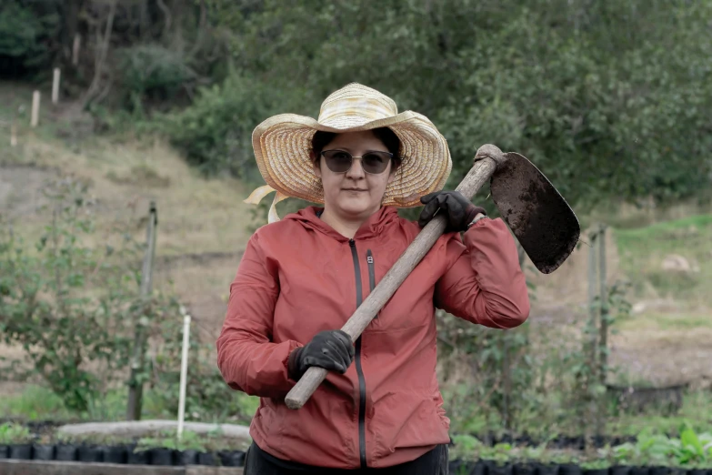 a woman holding up a shovel and gardening