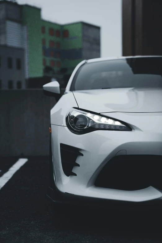 the front of a white toyota car with a street in background