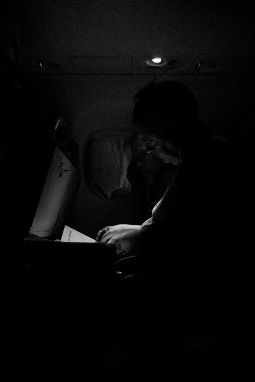 a man is staring at his phone while sitting in the dark