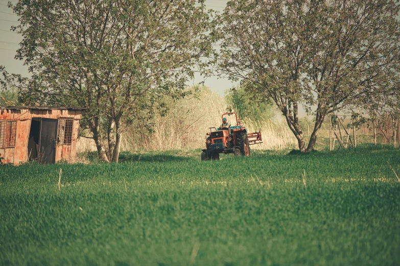 a man riding on the back of a green tractor