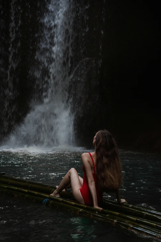 a woman in a red swimsuit in front of waterfall