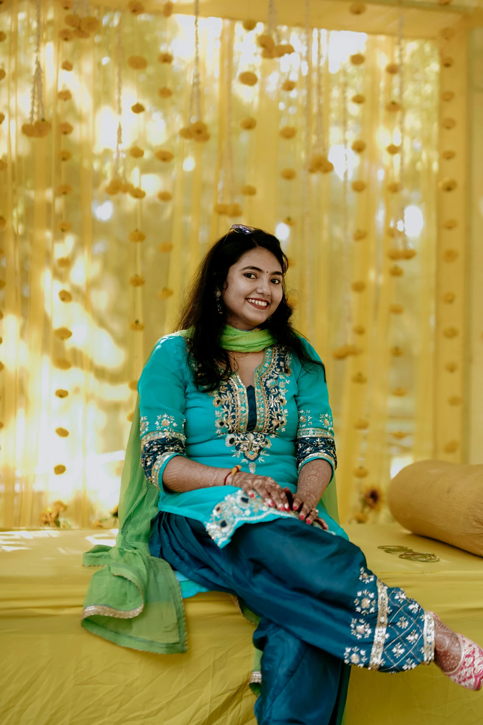 an attractive woman in a green outfit sitting on the bed