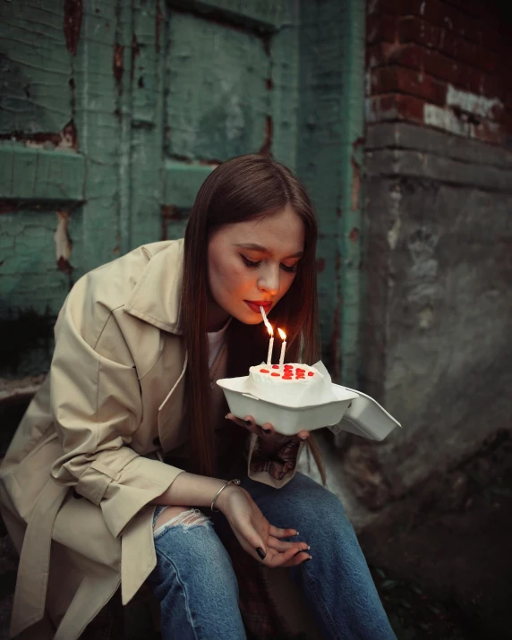 a woman sitting on a step holding a cake