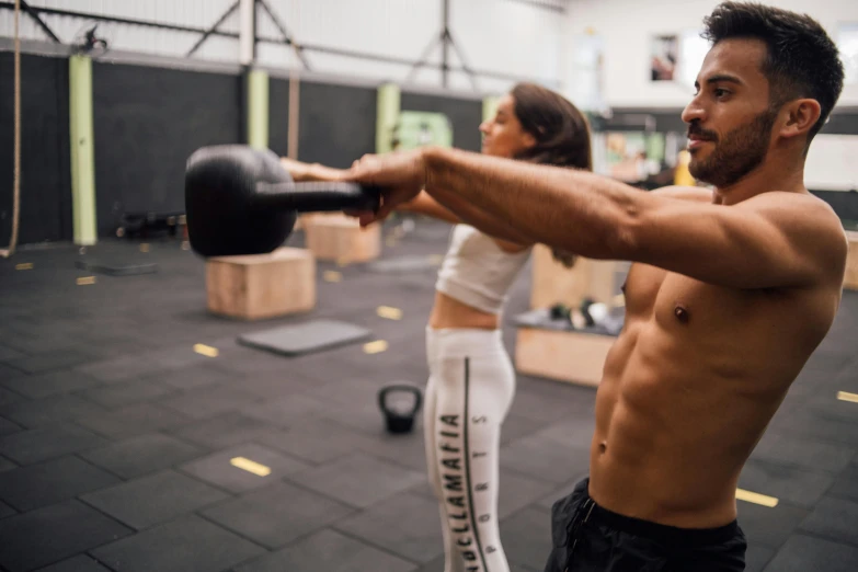 a man lifting a kettle during a gym class