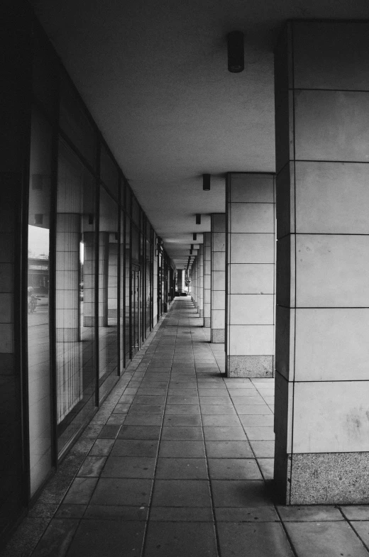 an empty walkway with glass doors leading to the sidewalk