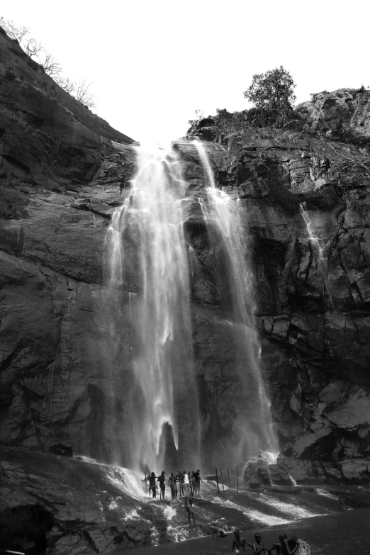 black and white pograph of people on top of a waterfall