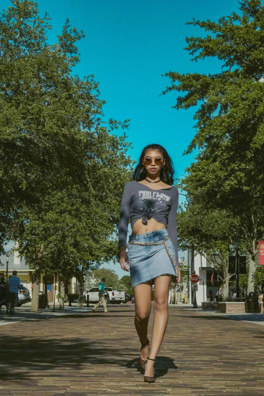 a woman is walking down a brick walk way