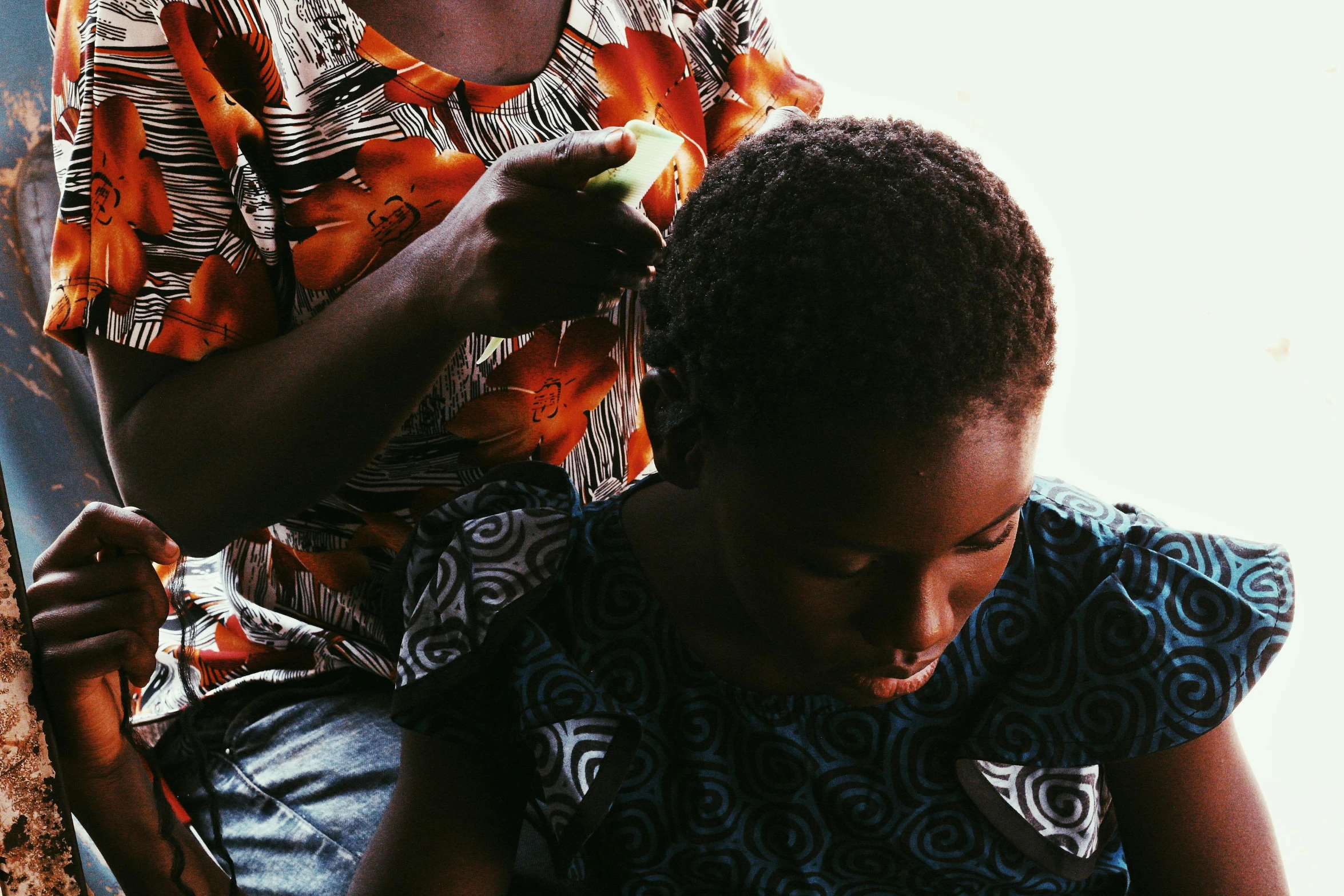 the mother cuts the daughter's hair with scissors