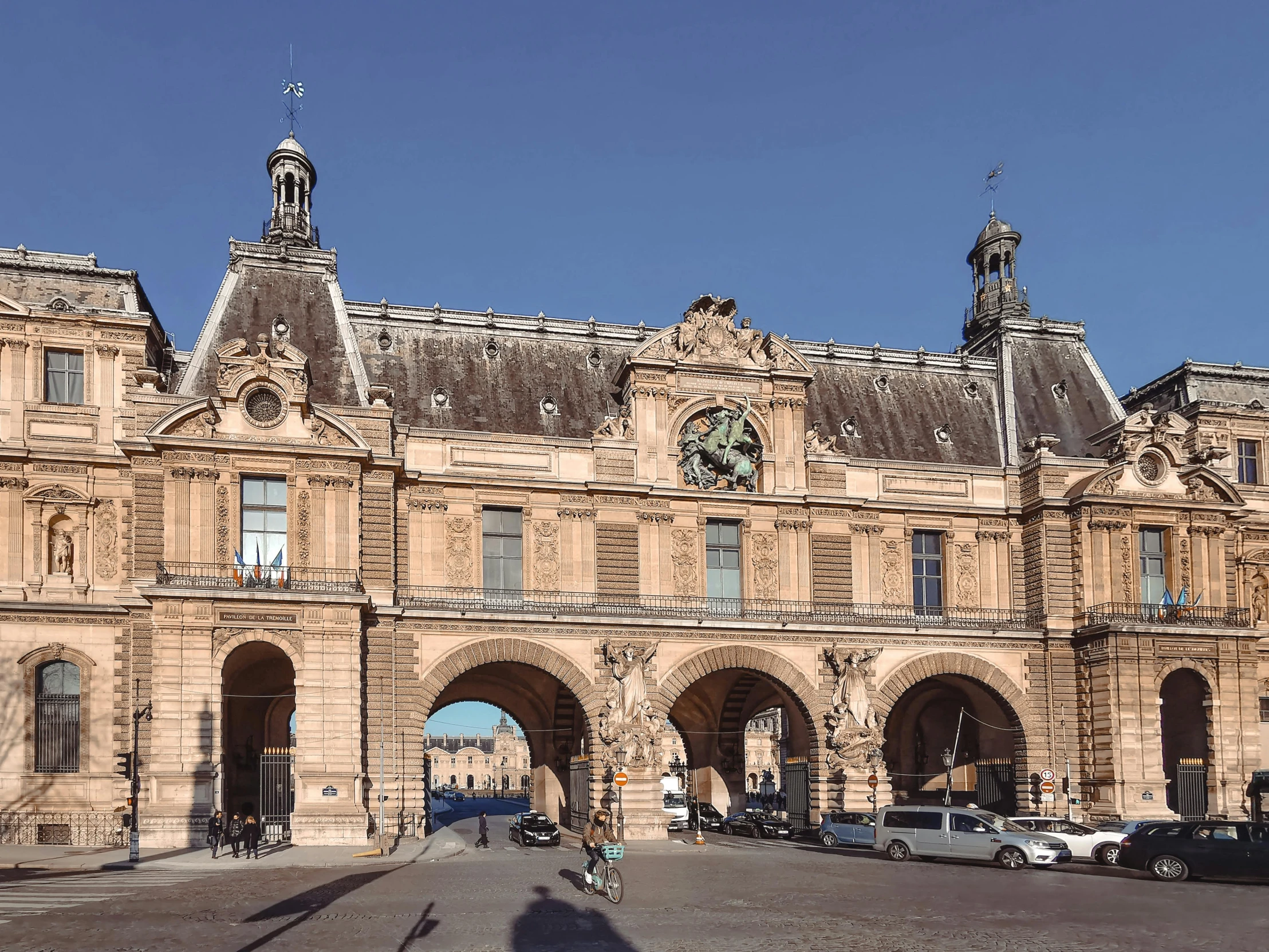 a building in a city with several statues on the top of it