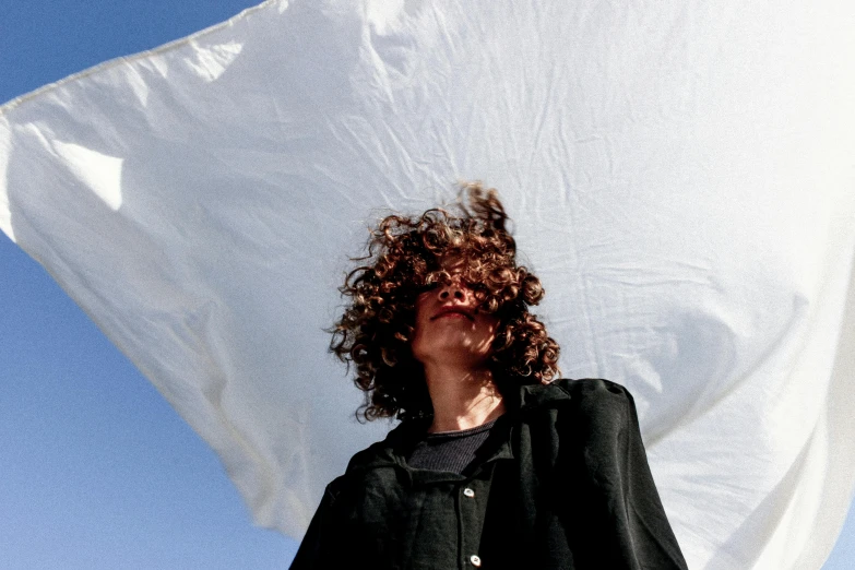 a woman that is standing next to a giant pillow