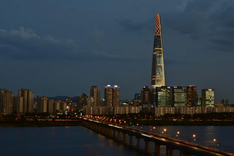 a city with a bridge over water and lights