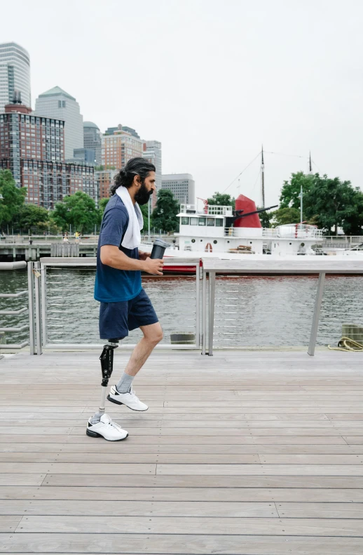 the man is walking on the boardwalk with a roller skate