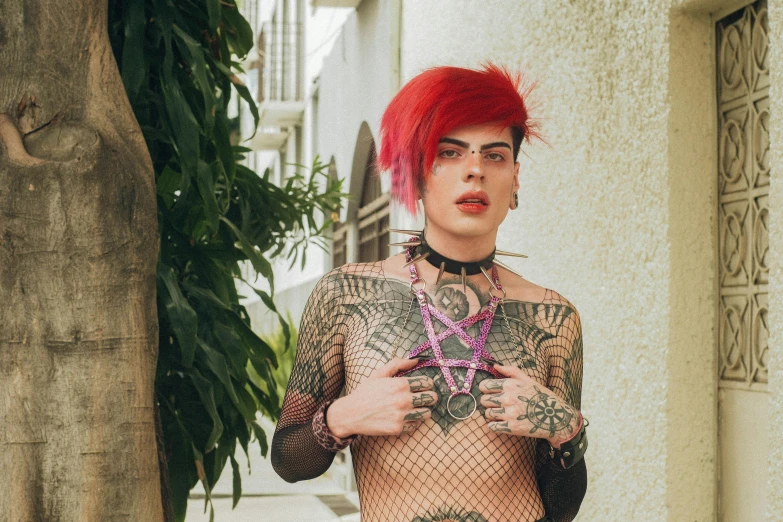there is a male with red hair in a fishnet and tattoo