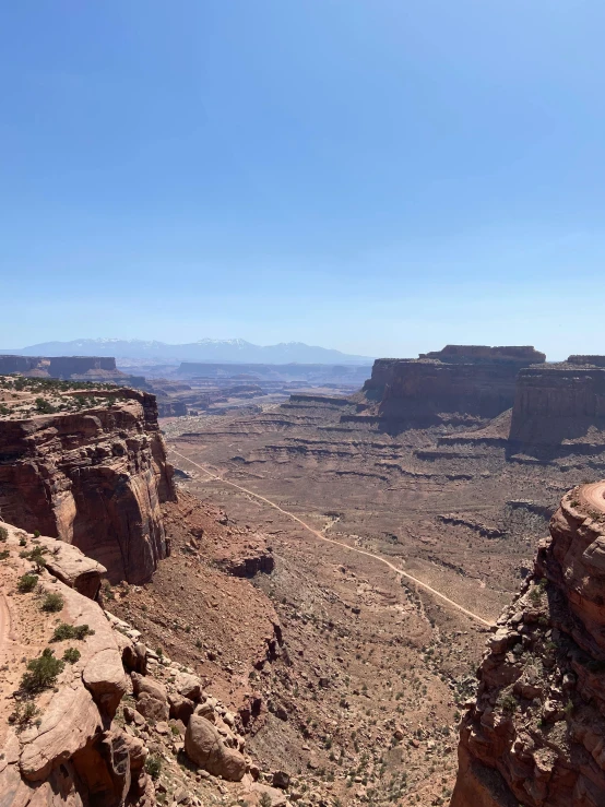 a person is standing on top of a cliff in the desert