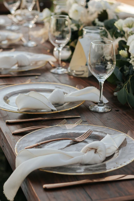 several white flowers are set on a wooden table