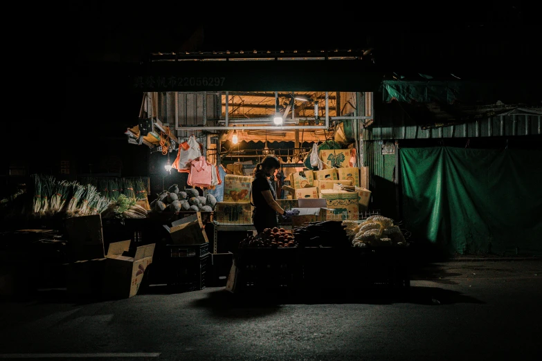 people standing next to stacks of boxes and other items at night