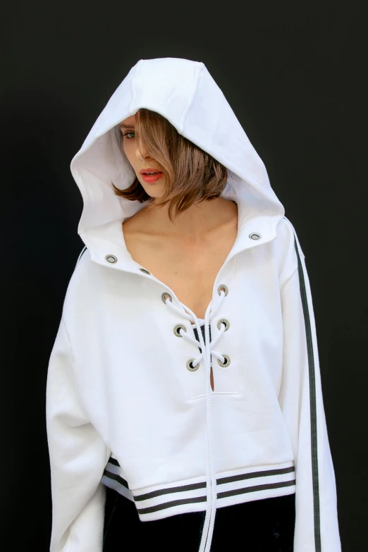 a woman wearing a white hooded sweatshirt with the hood up