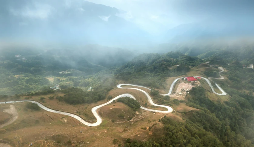 a pograph from above of a mountain road with cloudy skies