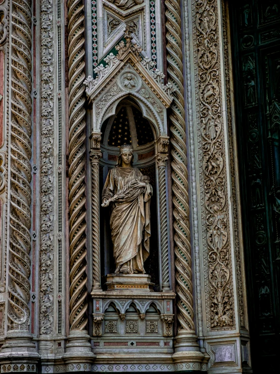 a stone statue on a building next to the window