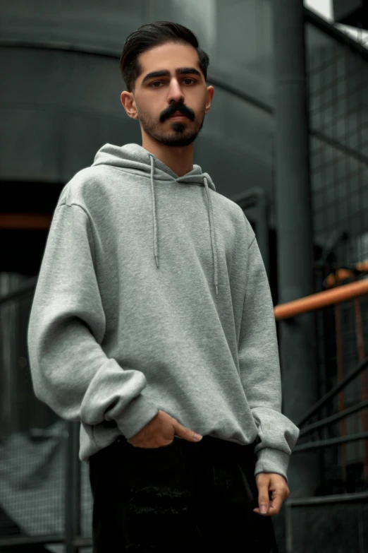 a man standing in front of a building with a mustache