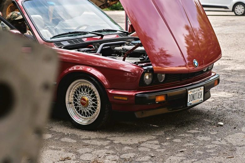 a red bmw is parked in the parking lot