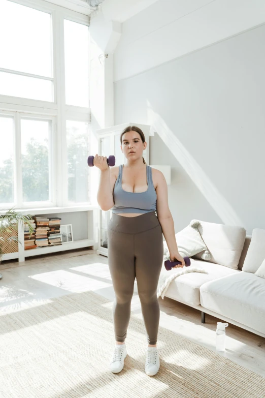 the young woman is posing with her pink and purple dumbs