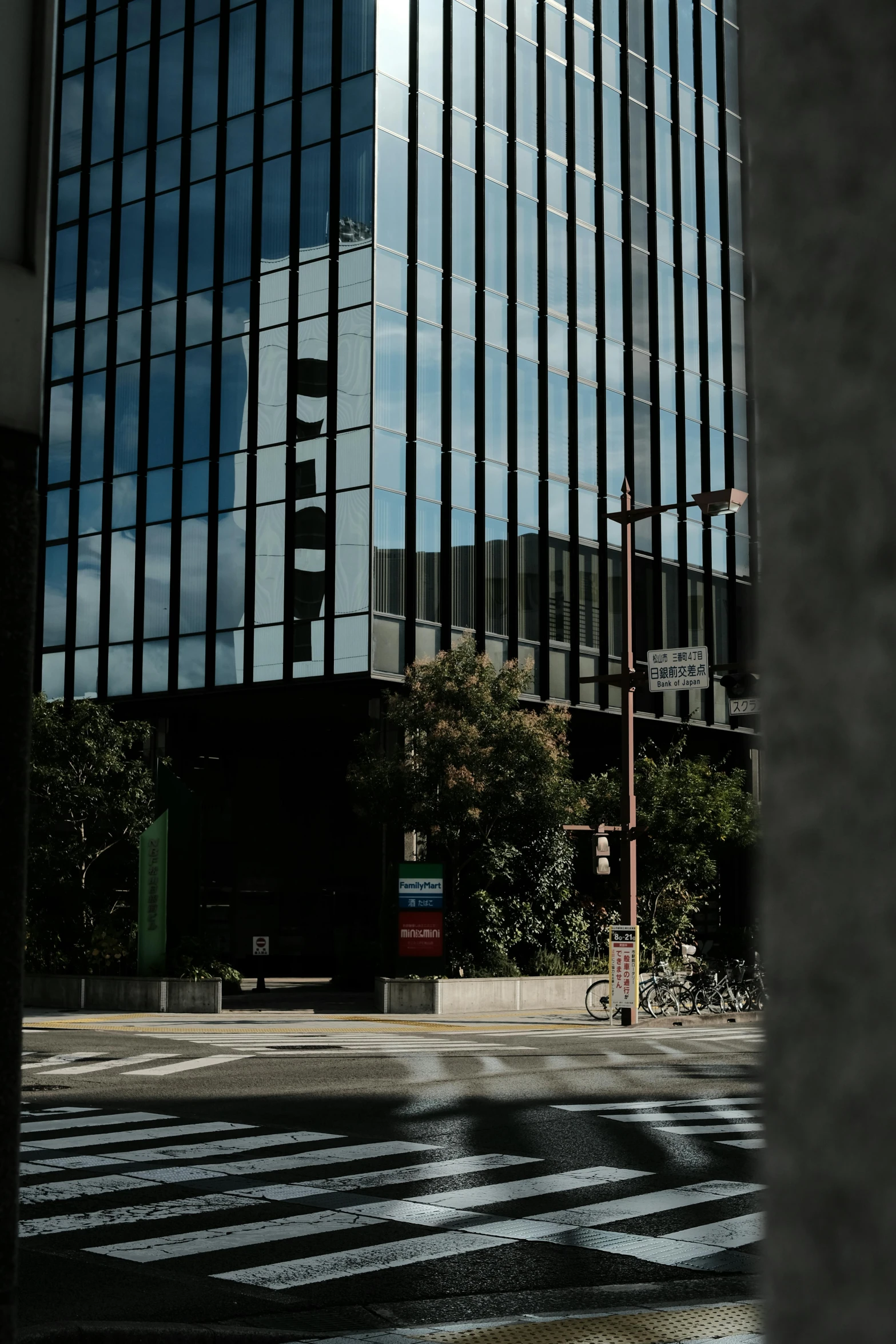 a tall black building across the street from a very large building