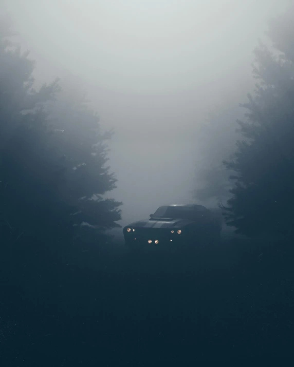 a car is driving down a road in the fog