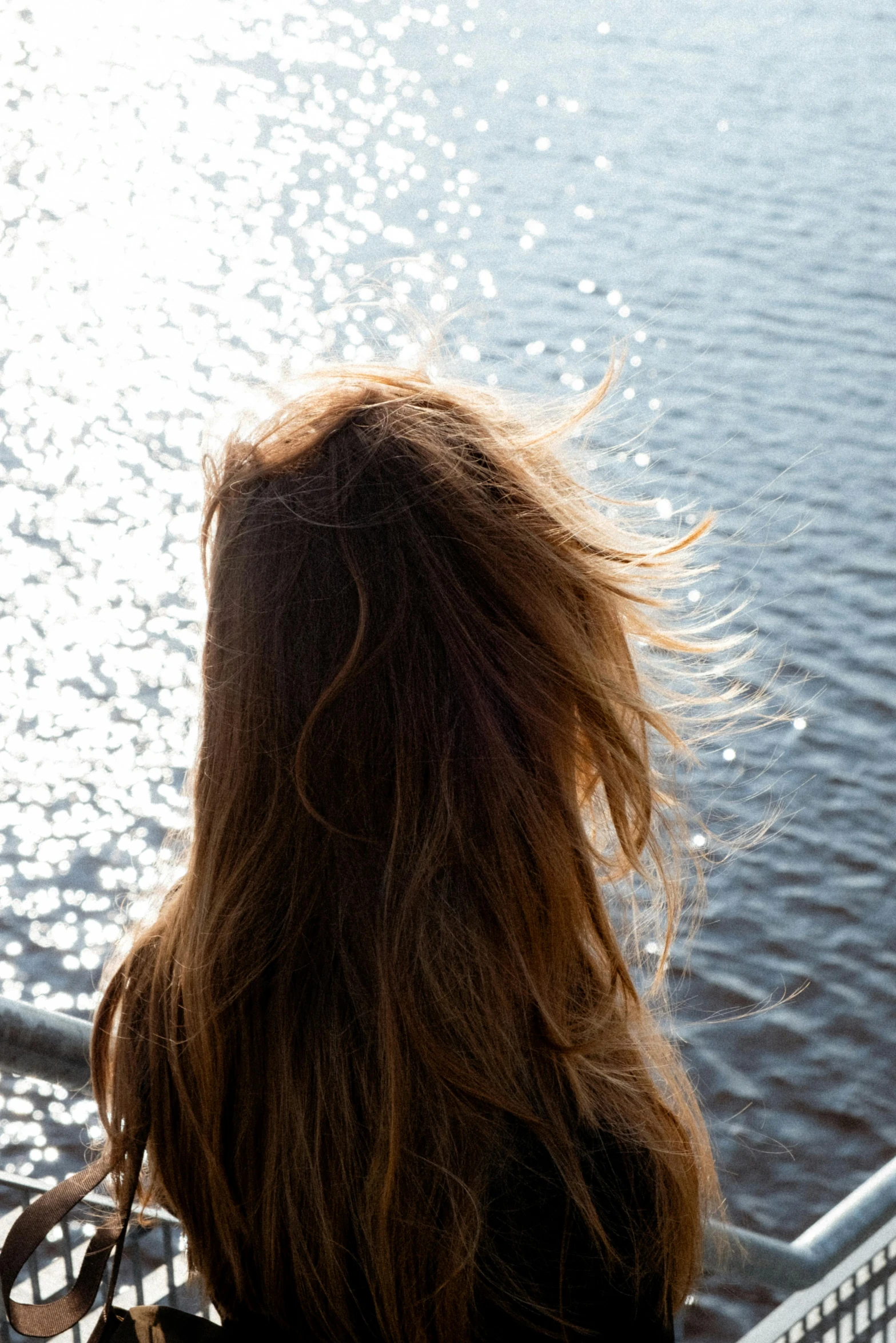 a woman looking over the railing at the water