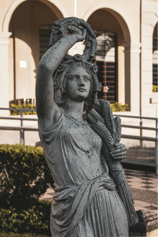 the statue is surrounded by several bushes and a building